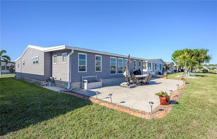 Rear view of house with a patio area and a yard