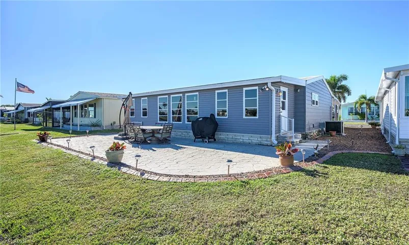 Rear view of house featuring a lawn and a patio area