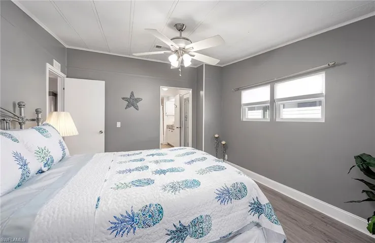 Bedroom with ceiling fan, dark hardwood / wood-style flooring, ensuite bathroom, and ornamental molding