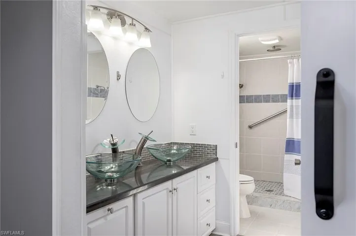 Bathroom featuring tile patterned floors, toilet, vanity, and walk in shower
