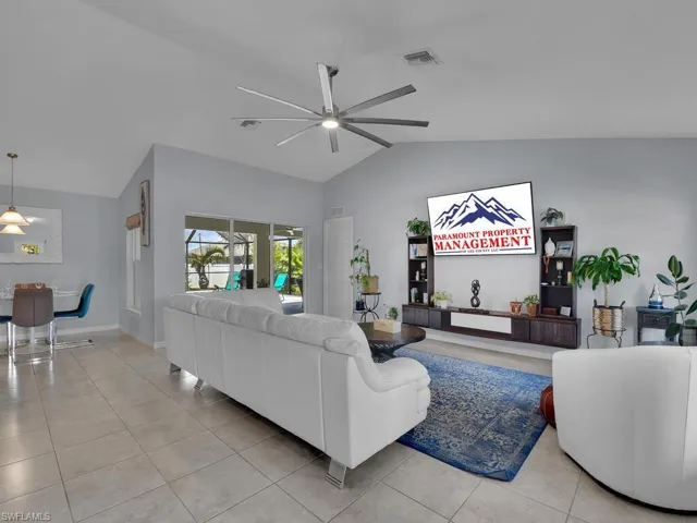 Tiled living room featuring vaulted ceiling and ceiling fan