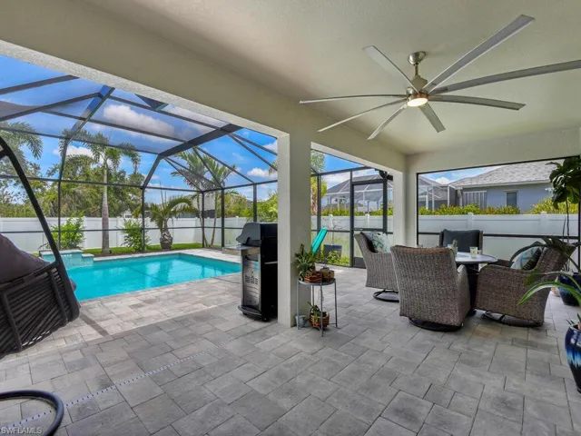 View of swimming pool with area for grilling, a patio area, glass enclosure, and ceiling fan