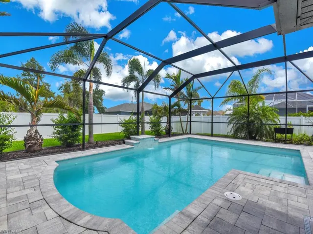 View of pool with a patio and glass enclosure