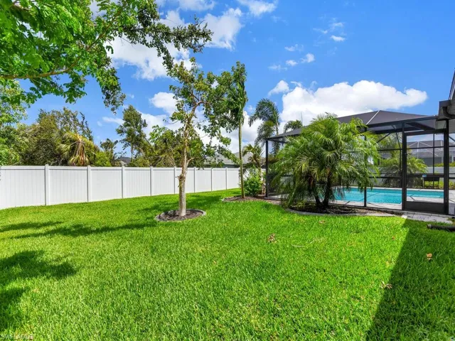 View of yard featuring a fenced in pool and glass enclosure