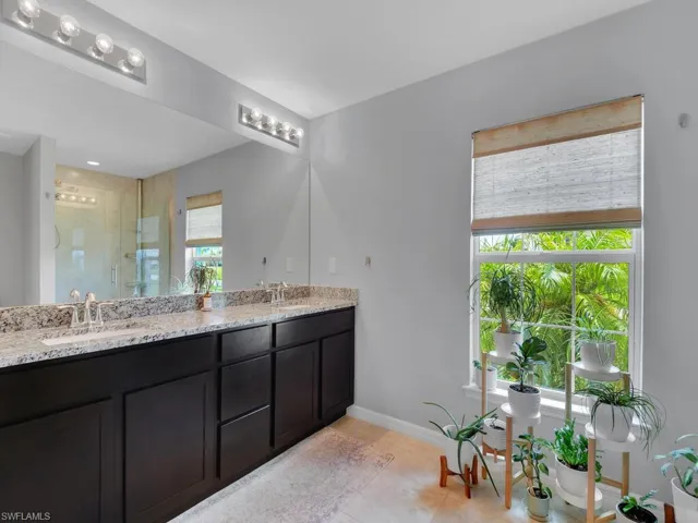 Bathroom with a shower with door, vanity, and tile patterned flooring