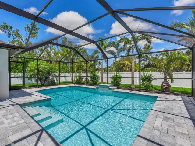 View of swimming pool with a patio area and glass enclosure