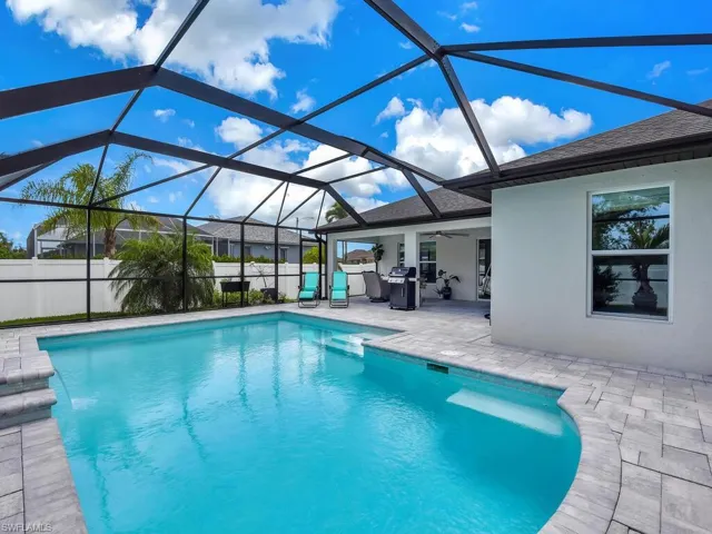 View of swimming pool featuring a patio, ceiling fan, grilling area, and glass enclosure