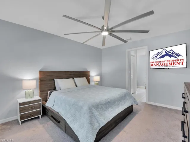 Bedroom with ceiling fan and light colored carpet