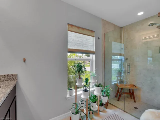 Bathroom with vanity, tile patterned floors, and a shower with door