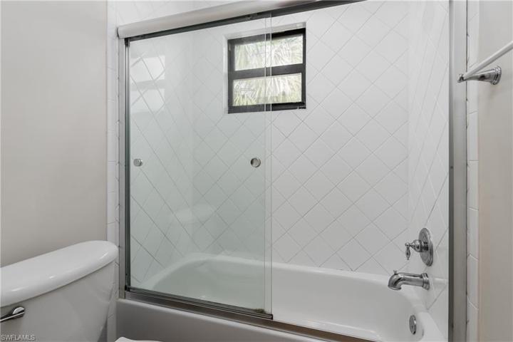 Guest bath tub/shower with white tile and window