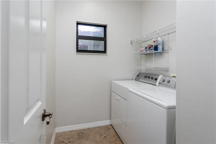 Inside laundry room holds full size washer and dryer