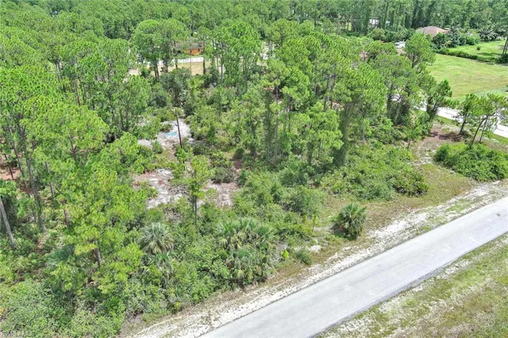 Aerial view of property and surrounding area featuring a forest