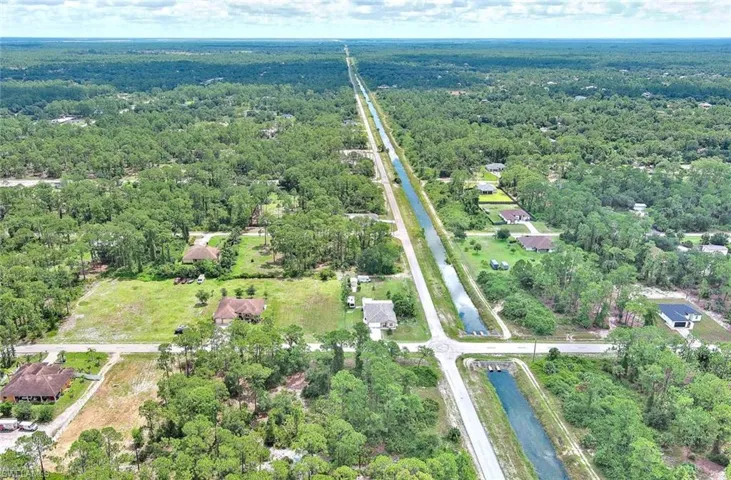 Aerial overview of property's location with a large body of water and a forest
