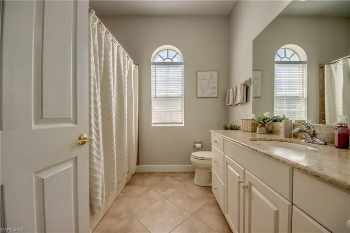 Full bath with vanity, a shower with shower curtain, and light tile patterned floors