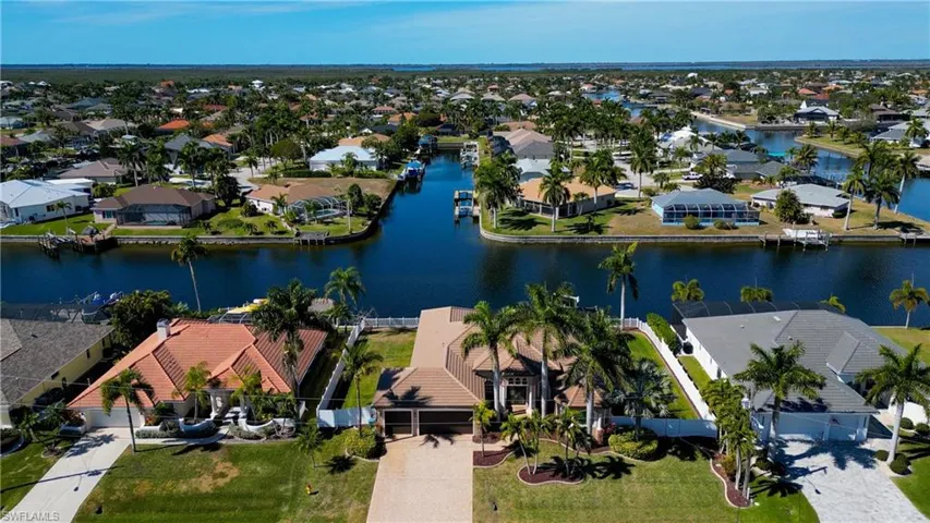 Aerial view of property and surrounding area featuring nearby suburban area and a nearby body of water
