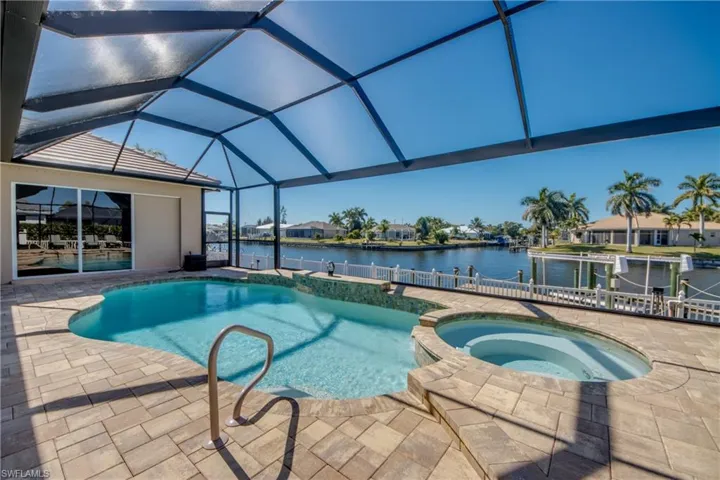 Integrated pool / spa with a patio, a residential view, a lanai, and a water view