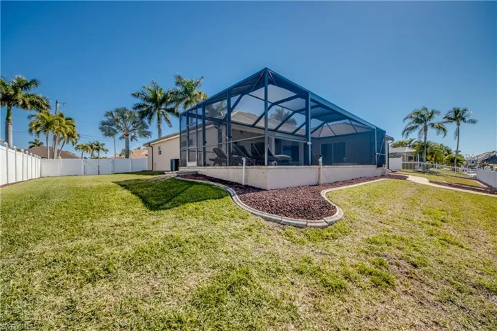Back of property with enclosure and a fenced backyard