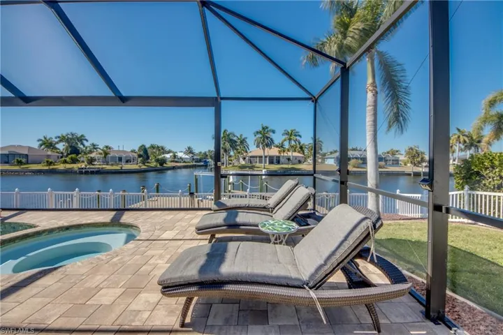 Swimming pool with a residential view, a water view, an oversized in-ground hot tub, and a patio area