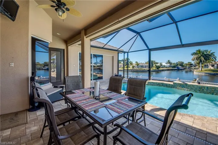 View of patio featuring an outdoor pool, ceiling fan, a lanai, and outdoor dining area