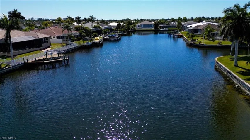 Water view featuring nearby suburban area and a boat dock