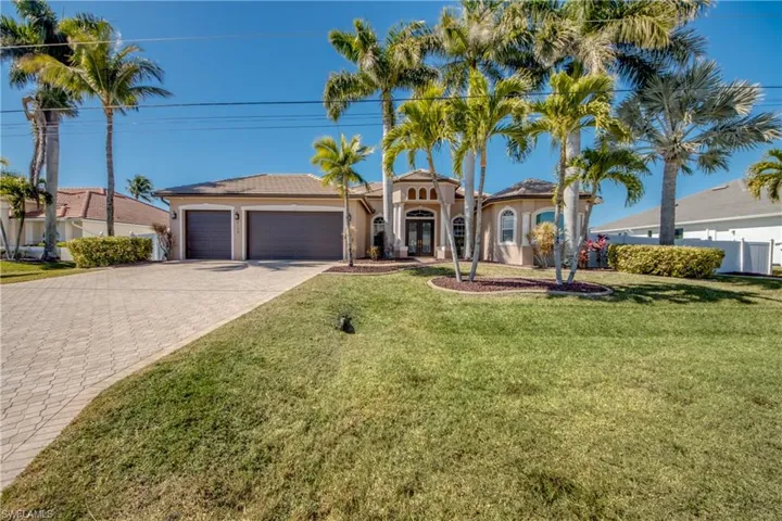 Mediterranean house featuring a 3 car garage, a front lawn, decorative driveway, and stucco siding