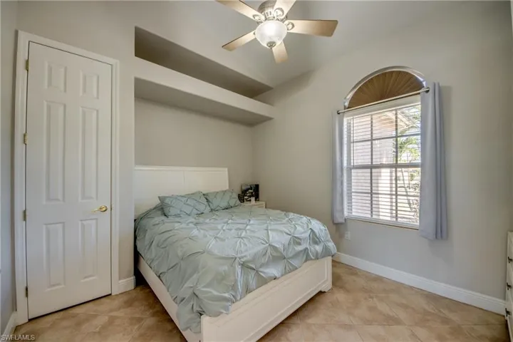 Bedroom with ceiling fan and light tile patterned floors