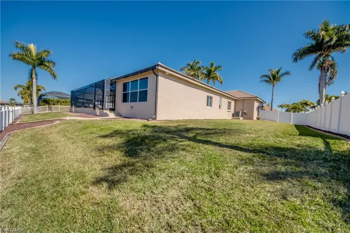 Rear view of property featuring a fenced backyard, a sunroom, stucco siding, and a lanai