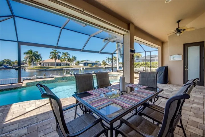 View of patio with a outdoor dining area, an outdoor pool, and a ceiling fan