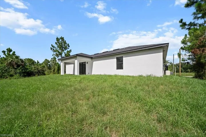 Rear view of property with stucco siding and an attached garage