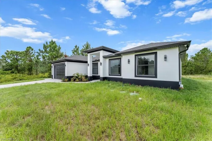 Prairie-style home with an attached garage, concrete driveway, and stucco siding