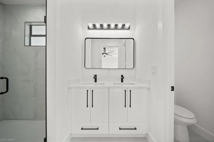 Bathroom with a marble finish shower and double vanity