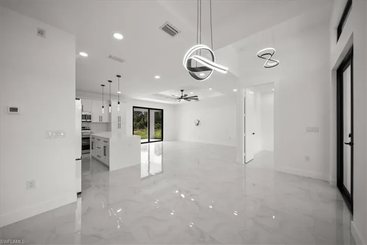 Unfurnished room with light marble finish flooring, recessed lighting, a raised ceiling, and ceiling fan