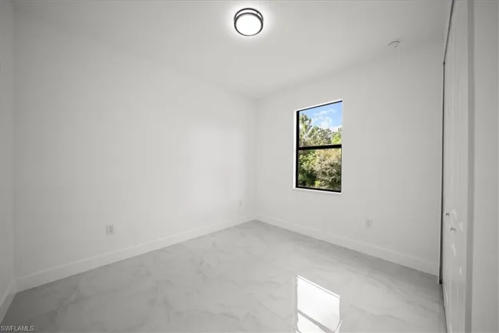 Spare room with light marble finish floors and baseboards
