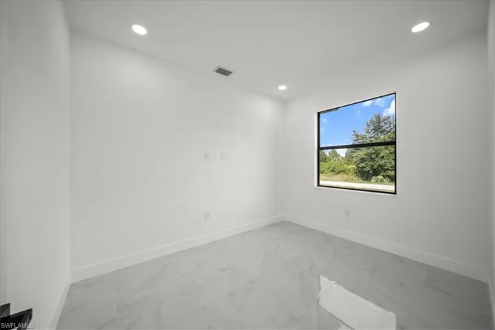 Spare room featuring light marble finish floors and recessed lighting