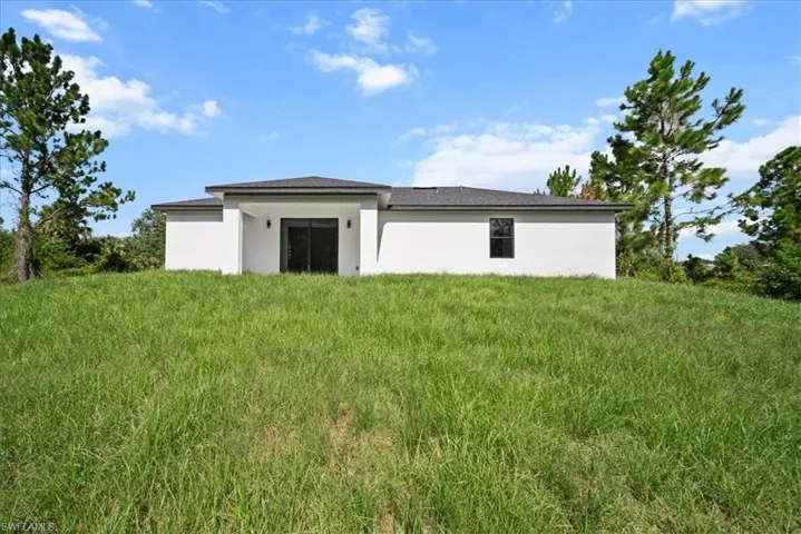 Back of property featuring stucco siding