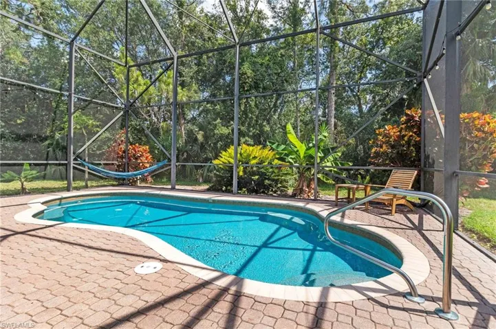 View of pool featuring a patio and glass enclosure