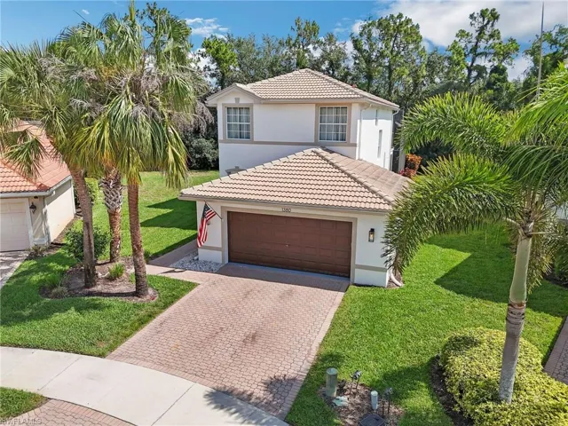 Mediterranean / spanish-style house with a garage and a front lawn