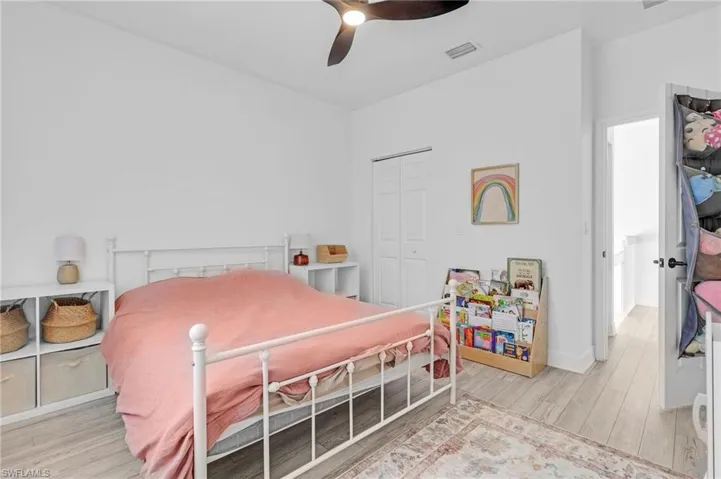 Bedroom with a closet, ceiling fan, and light hardwood / wood-style floors