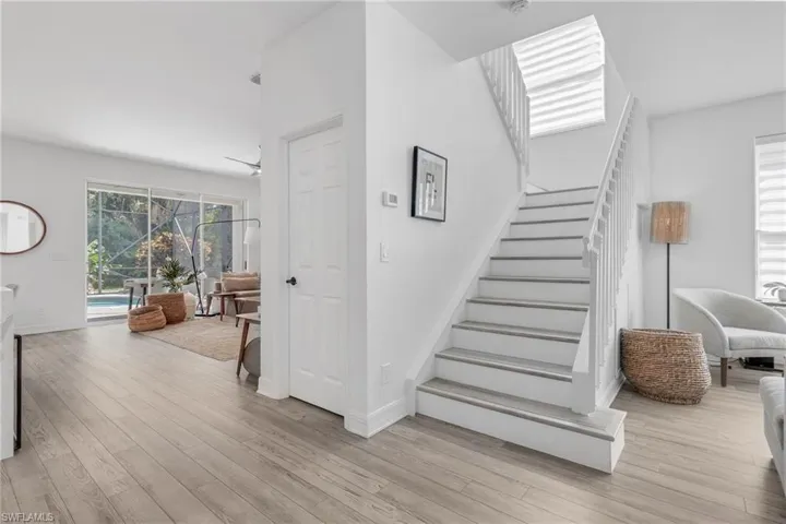 Stairway with ceiling fan and light hardwood / wood-style floors