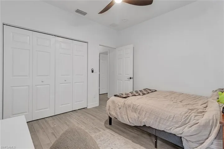 Bedroom with a closet, ceiling fan, and light hardwood / wood-style floors