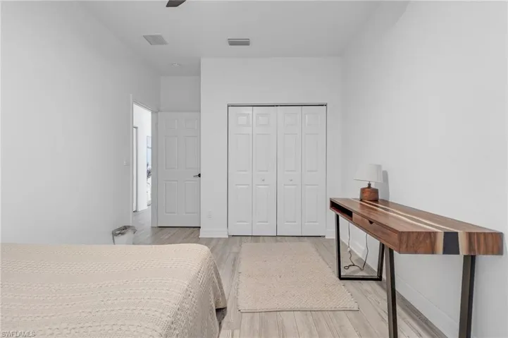 Bedroom with ceiling fan, a closet, and light hardwood / wood-style flooring
