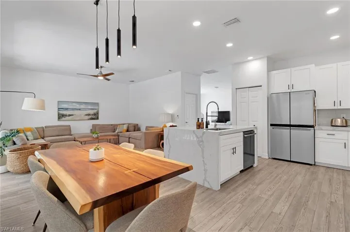 Dining space with ceiling fan, light hardwood / wood-style flooring, and sink