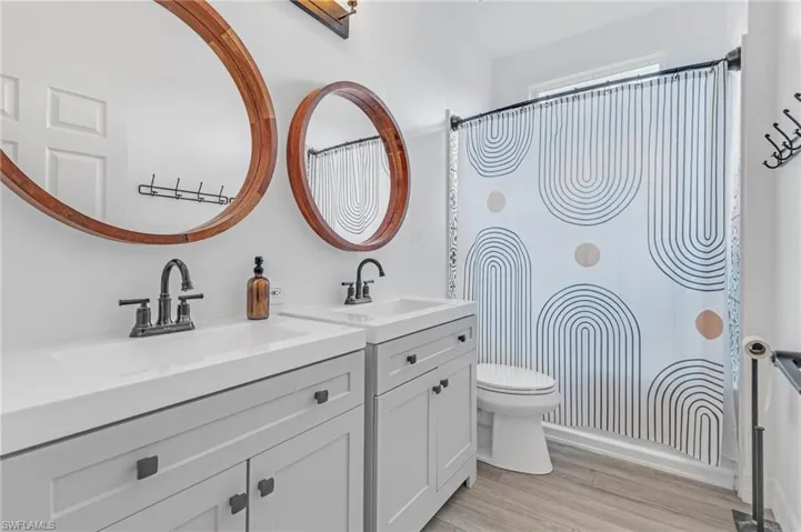 Bathroom featuring oversized vanity, toilet, and hardwood / wood-style floors