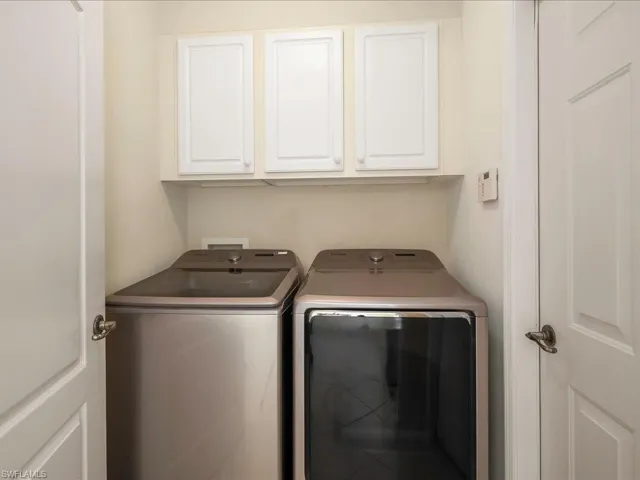 Laundry area featuring washing machine and clothes dryer and cabinet space