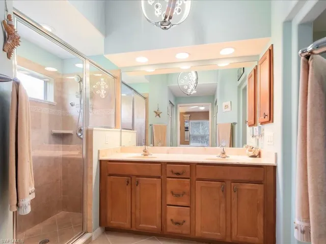Full bath with a stall shower, double vanity, recessed lighting, and tile patterned flooring