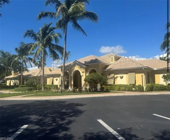 Mediterranean / spanish-style house featuring stucco siding, a tile roof, and uncovered parking