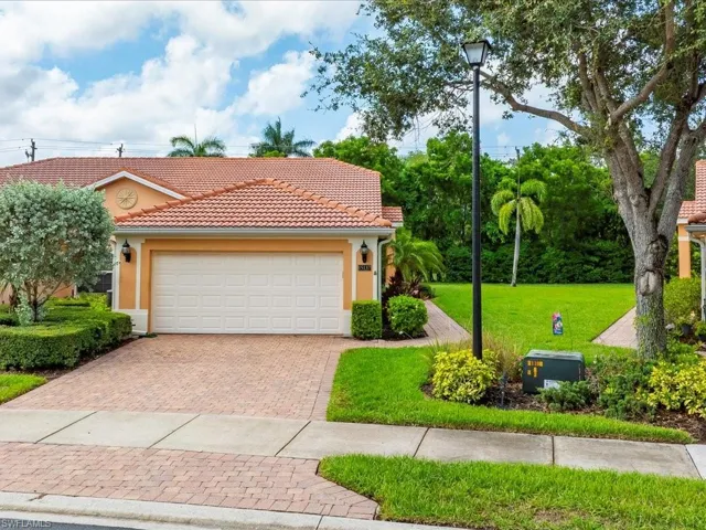 Mediterranean / spanish-style home with a front yard, a tile roof, decorative driveway, stucco siding, and a garage