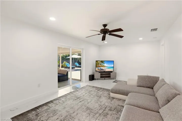 Living room featuring ceiling fan, light marble finish floors, and recessed lighting