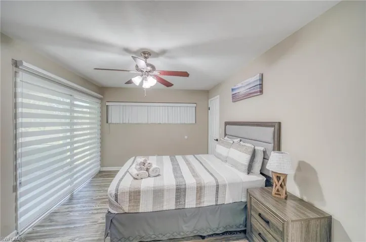 Bedroom featuring light wood-type flooring, baseboards, and ceiling fan