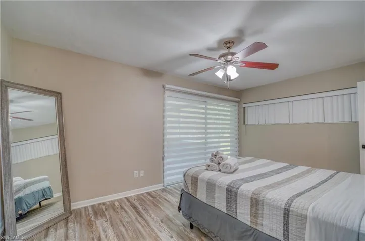 Bedroom featuring light wood-style flooring, baseboards, and ceiling fan